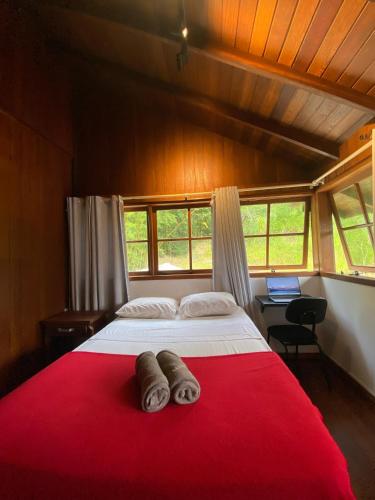 a bedroom with a large bed with a red blanket at Nômades Riverside - Adventure Hostels & Coworking in Florianópolis