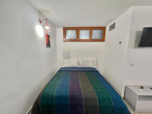a bedroom with a bed with a colorful blanket at Abruzzi Home in Cologno Monzese