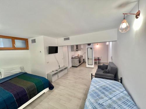 a bedroom with a bed and a couch and a chair at Abruzzi Home in Cologno Monzese