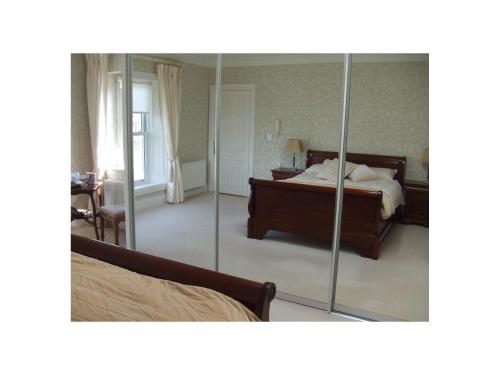 a bedroom with a bed and a mirror at Ambrose Mews B&B in Duncormick