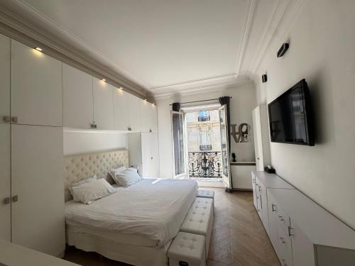 une chambre blanche avec un lit et une télévision dans l'établissement Luxury appartement 165m2 Paris 16 Victor Hugo Etoile AC, à Paris