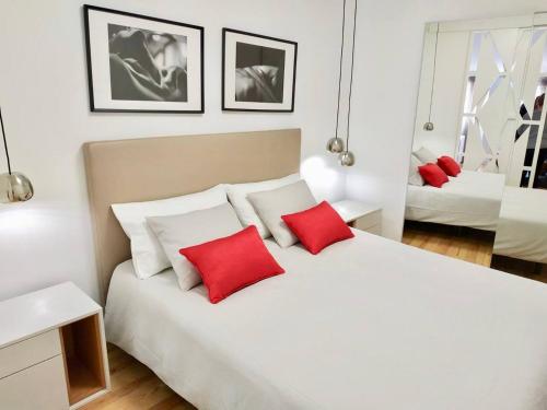 Un dormitorio con una cama blanca con almohadas rojas. en Beautiful & Unique Alfama flat, en Lisboa
