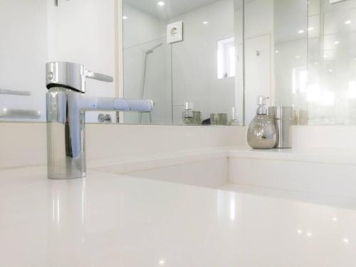 Un baño blanco con lavabo y espejo. en Beautiful & Unique Alfama flat, en Lisboa