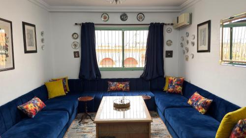 a living room with blue couches and a table at شقة الفن Art Apartment in Marrakech
