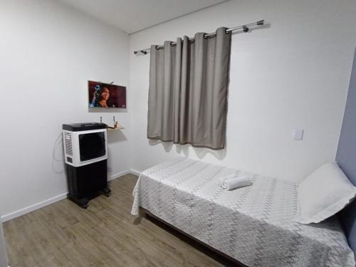 a small room with a bed and a television at Casa do Naldo in Brasília