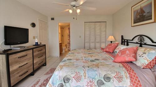 Tavernierにある2306 Ocean Pointe Suitesのベッドと薄型テレビのある寝室