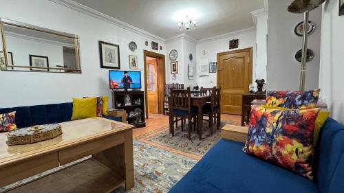 a living room with a blue couch and a dining room at شقة الفن Art Apartment in Marrakech