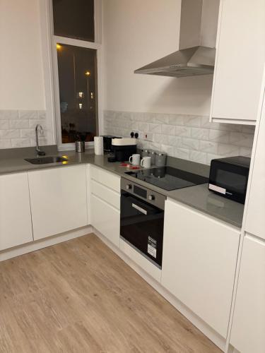 a kitchen with white cabinets and a black stove at The Lookout in Cove