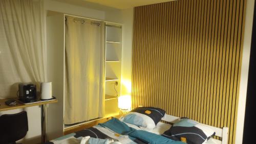 - une chambre avec un lit et une fenêtre avec une lampe dans l'établissement La tanière des Papes, à Avignon