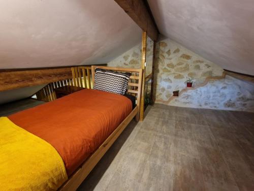 a bedroom with a bed in a attic at Organic and artistic home in Payrignac