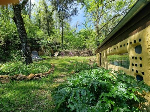 a garden with a bench in the grass at Organic and artistic home in Payrignac