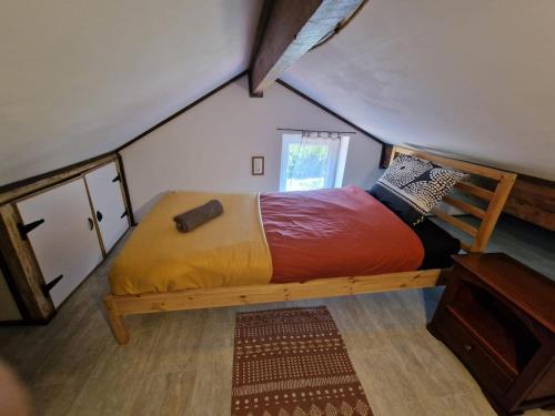 a bed in the middle of a room in a attic at Organic and artistic home in Payrignac