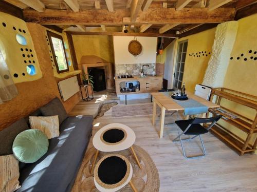 a living room with a couch and a table at Organic and artistic home in Payrignac