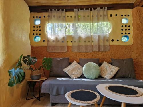 a living room with a couch and a window at Organic and artistic home in Payrignac
