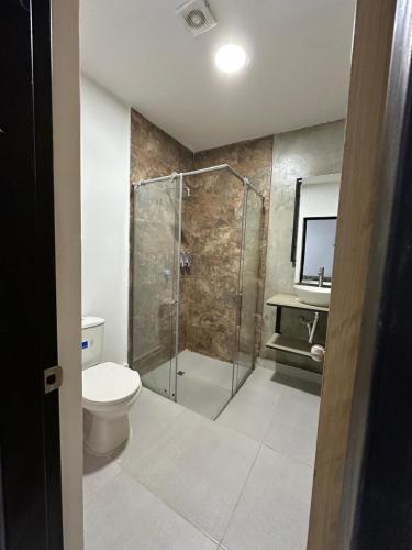 a bathroom with a shower and a toilet and a sink at Nómada22 -Hostal moderno en el centro de Neiva in Neiva