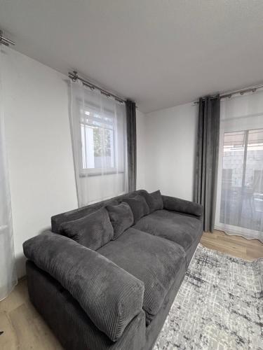 a couch in a living room with two windows at Terrace 24 Urban Stay in Villingen-Schwenningen