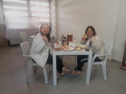 two women sitting at a table eating food at Mmarros Inn in Cusco