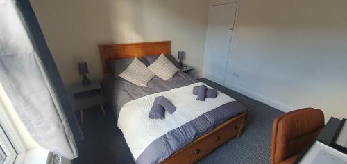 ein Schlafzimmer mit einem Bett mit zwei Hausschuhen darauf in der Unterkunft Simple, cosy and comfortable 3 beds in Kings Lynn