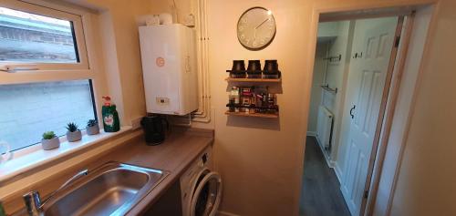 eine Küche mit Spüle und Waschmaschine in der Unterkunft Simple, cosy and comfortable 3 beds in Kings Lynn