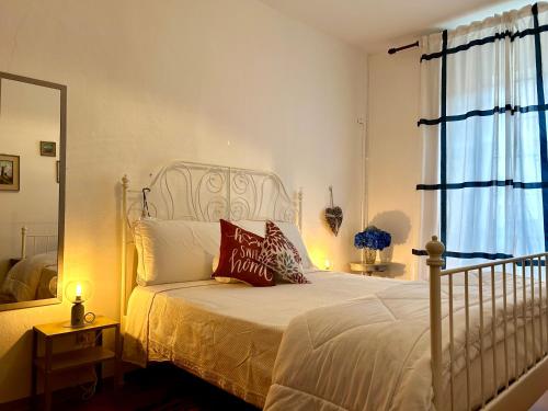 a bedroom with a white bed with pillows and a mirror at Blue Breeze Apartment in Germignaga