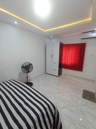 a bedroom with a black and white bed and red cabinets at Crystal homes in Lagos
