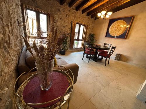 a living room with a table with a vase on it at ¡Carlo Crivelli Master: el estilo en Val'Quirico! in Santeagueda