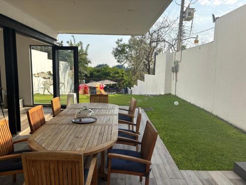 a wooden table and chairs on a patio at Casa del Unicornio Azul in Cocoyoc