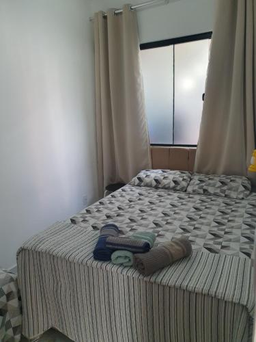 a bed with two towels on it with a window at Quarto & Conforto in Penha