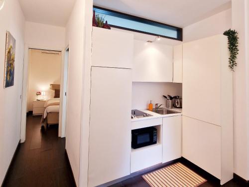 a small kitchen with white cabinets and a sink at Donna Rosa - Main Avenue in Taormina
