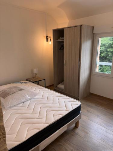 a bedroom with a large bed and a closet at Appartement T3 - Plage à 500m in Saint-Nazaire