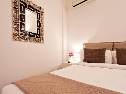 a bedroom with a bed and a mirror on the wall at Donna Rosa - Main Avenue in Taormina