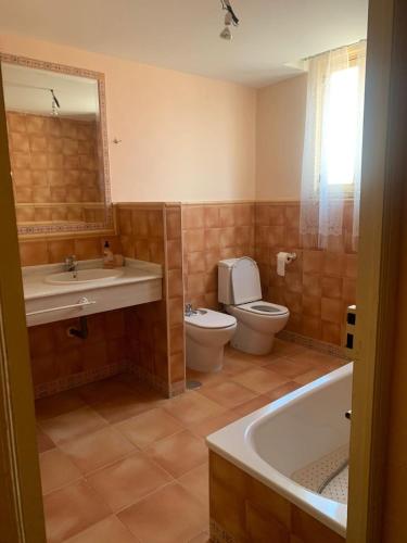 a bathroom with a toilet and a sink and a tub at Alojamiento Rural - El Rocin in Elche de la Sierra