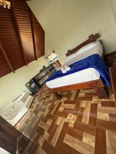 a bedroom with a bed and a wooden floor at Posada Acevedo in Paraíso