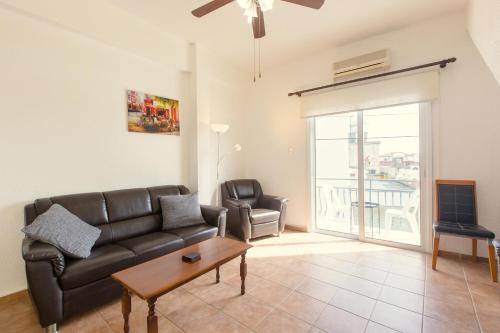 a living room with a couch and a table at Spacious Larnaca Beach Apartment in Larnaka