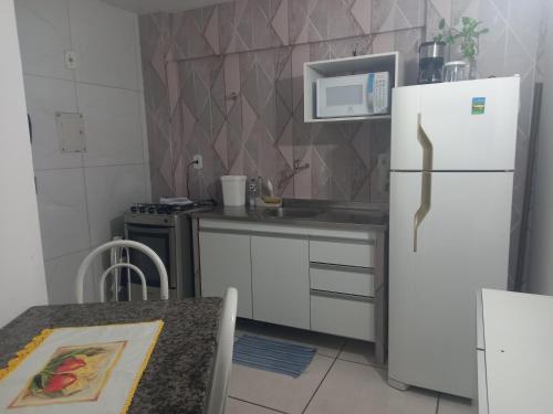 Una cocina con un refrigerador blanco y un microondas. en Cantinho Côte d'azur Maceió, en Maceió