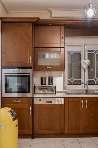 a kitchen with wooden cabinets and stainless steel appliances at Anastasia Meteora Residence in Kalabaka
