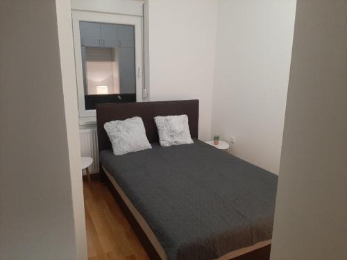 a bedroom with a bed with two pillows on it at Apartman Beograd Mir i Komfor in Belgrade