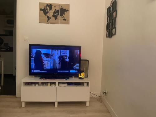 a flat screen tv sitting on a white cabinet at Appartement Montrouge in Montrouge