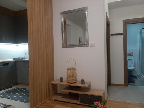 a bathroom with a mirror and a table with a sink at Apartman Beograd Mir i Komfor in Belgrade