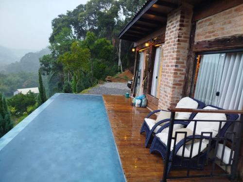 a porch of a house with a view of the mountains at Cabana Herança do Vovô in Domingos Martins
