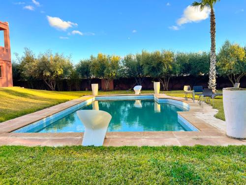 马拉喀什Villa Zeen Garden的一个带两把白色椅子的游泳池