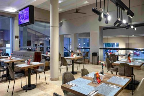 a restaurant with tables and chairs and a flat screen tv at Casa Andina Premium Piura in Piura