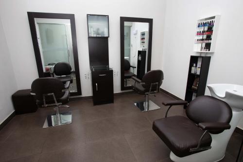 a salon with four chairs and a sink and mirrors at Casa Andina Premium Piura in Piura