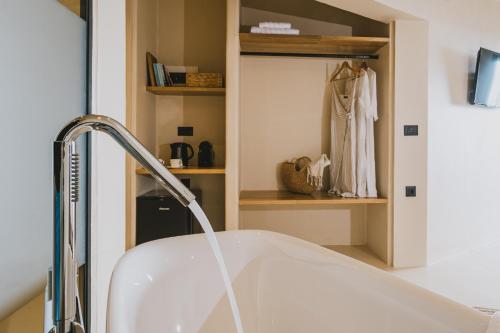 a white sink in a bathroom with a towel rack at Viento Luxury Apartments in Plomarion