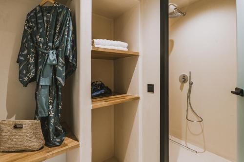 a bathroom with a robe hanging on a closet at Viento Luxury Apartments in Plomarion