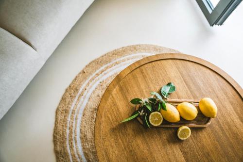a wooden cutting board with lemons on it at Viento Luxury Apartments in Plomarion