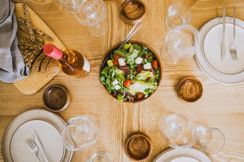 a table with a salad and a bowl of food at Viento Luxury Apartments in Plomarion