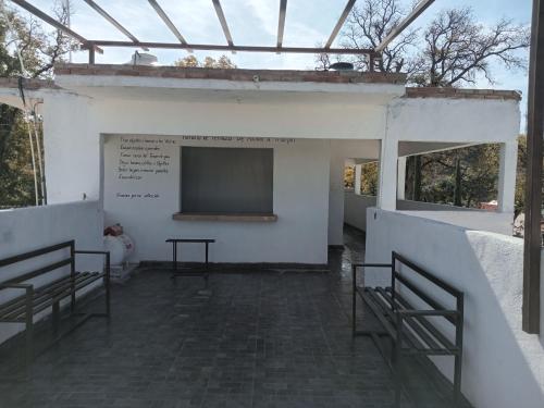 a building with a screen with two chairs and a table at La Terraza-Habitación 2 in Parras de la Fuente