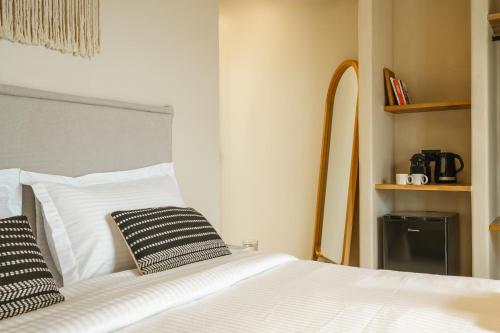 a bedroom with a white bed with two black and white pillows at Viento Luxury Apartments in Plomarion