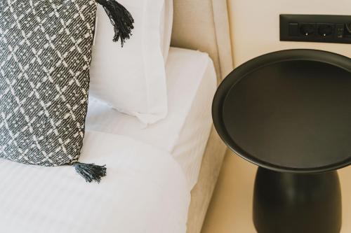 a bed with a black night stand next to a bed at Viento Luxury Apartments in Plomarion